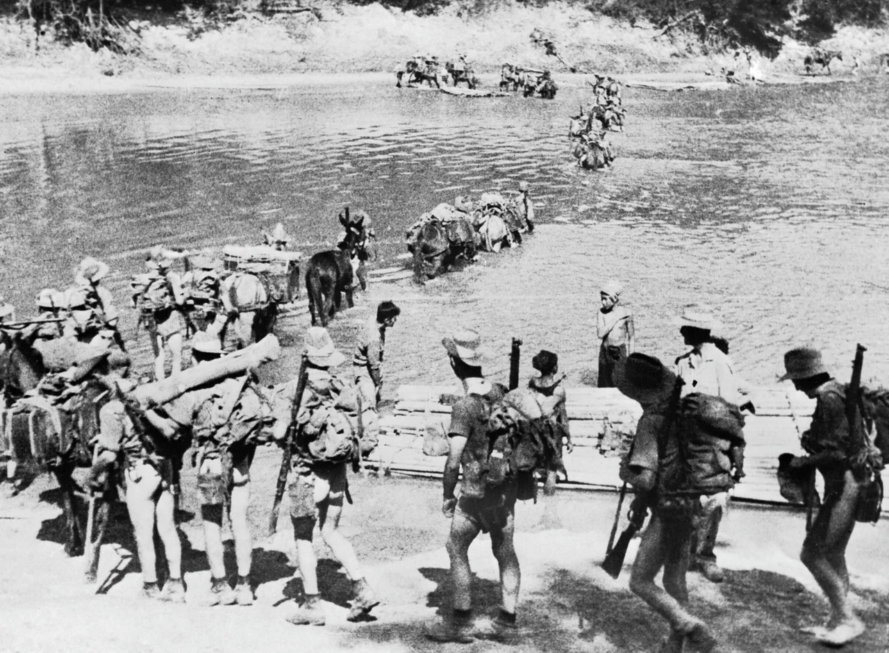 IWM caption : THE CHINDITS. Chindit Operations - General: A Chindit column crossing a river in Burma, 1943.