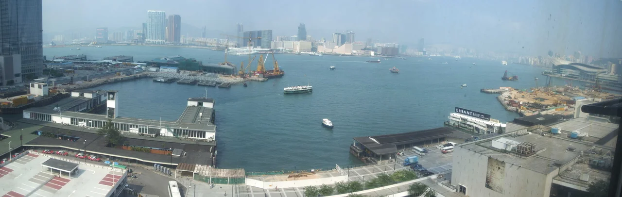 View of Star Ferry and Queen's Pier being engulfed by reclamation projects in Victoria Harbour. Taken from 10th Floor, City Hall High Block, Central, Hong Kong on 14 October 2005 by Carlsmith.