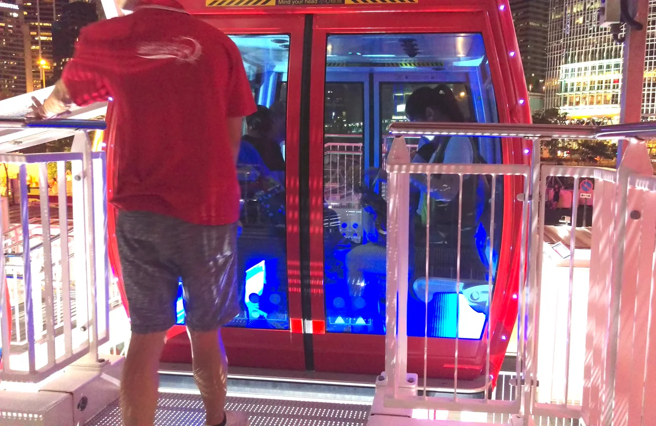 A close shot of the gondola of the Hong Kong Observation Wheel in July 2018, with the back of the staff and guests inside.