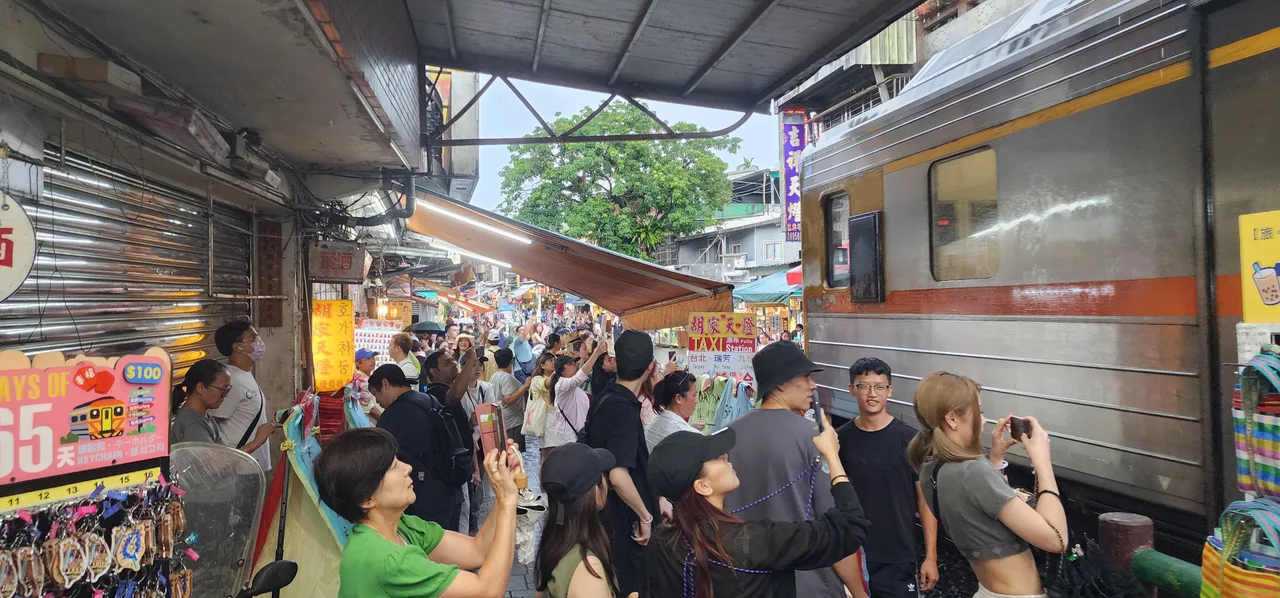 Train passes through crowds of tourists on the railway line in Shifen.